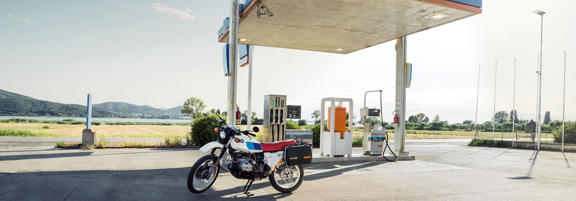 A motorbike is parked in front of a gas station