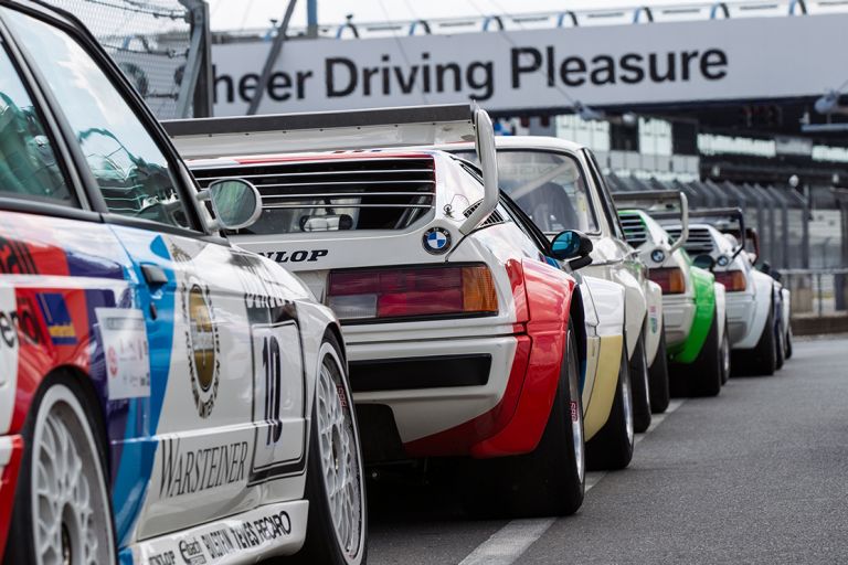 Rückansicht hintereinander stehender historischer BMW Rennwagen