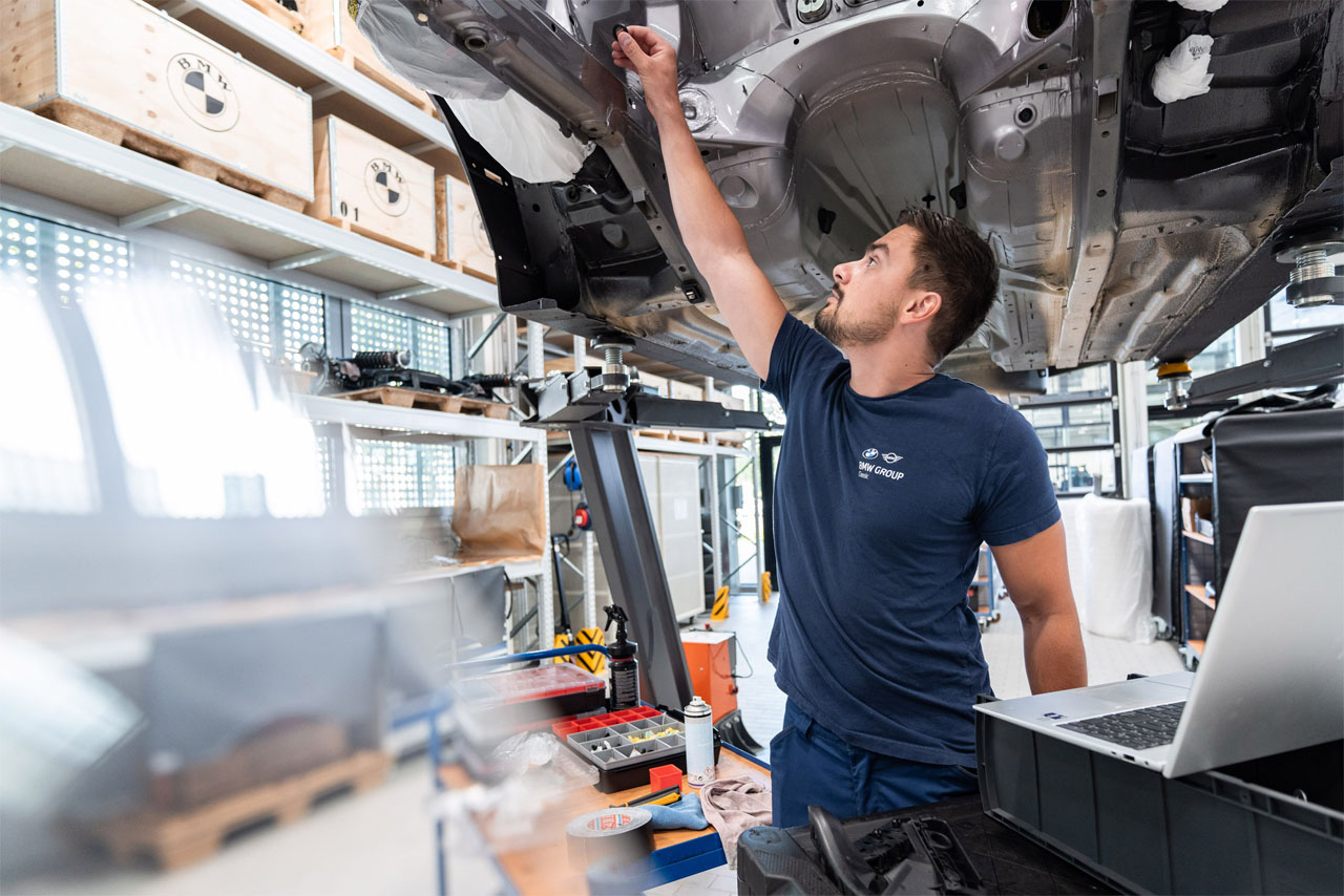 Mitarbeiter der BMW Group bei der Restaurierung eines BMW Modells.