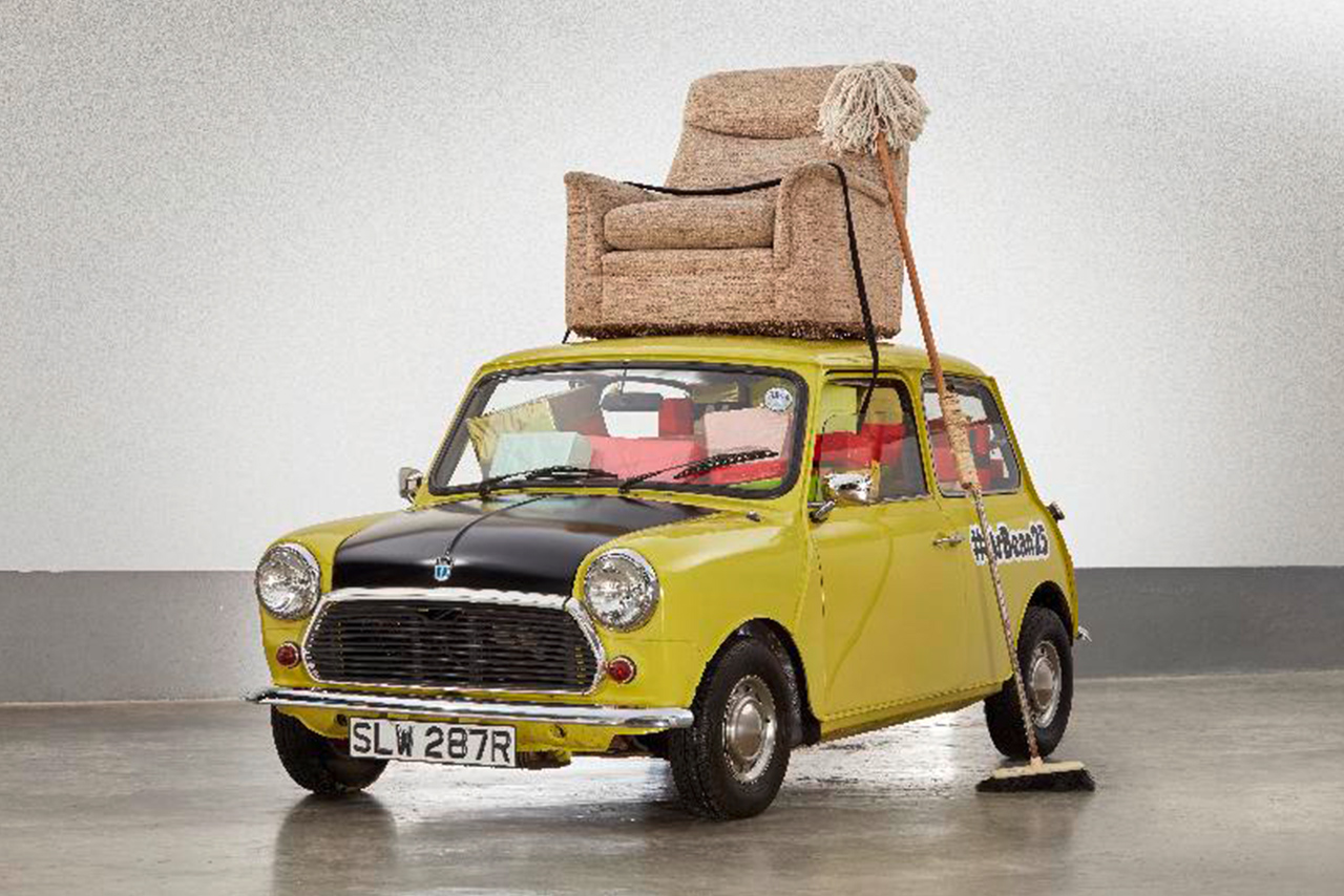 Historisches Auto transportiert Sessel auf dem Dach