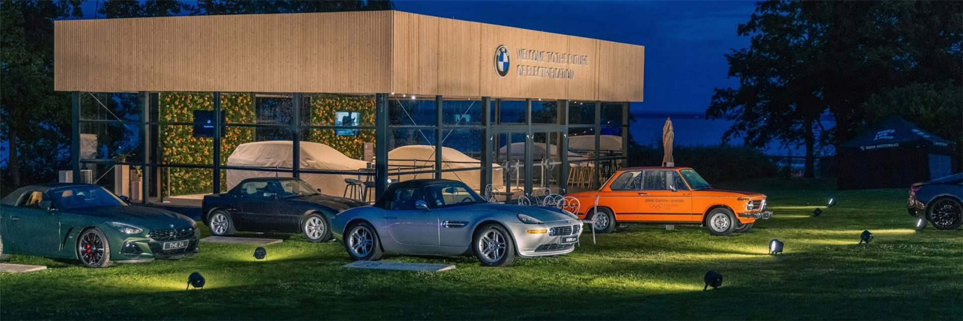 BMW Art Cars parken auf einer Wiese vor einem Museum.