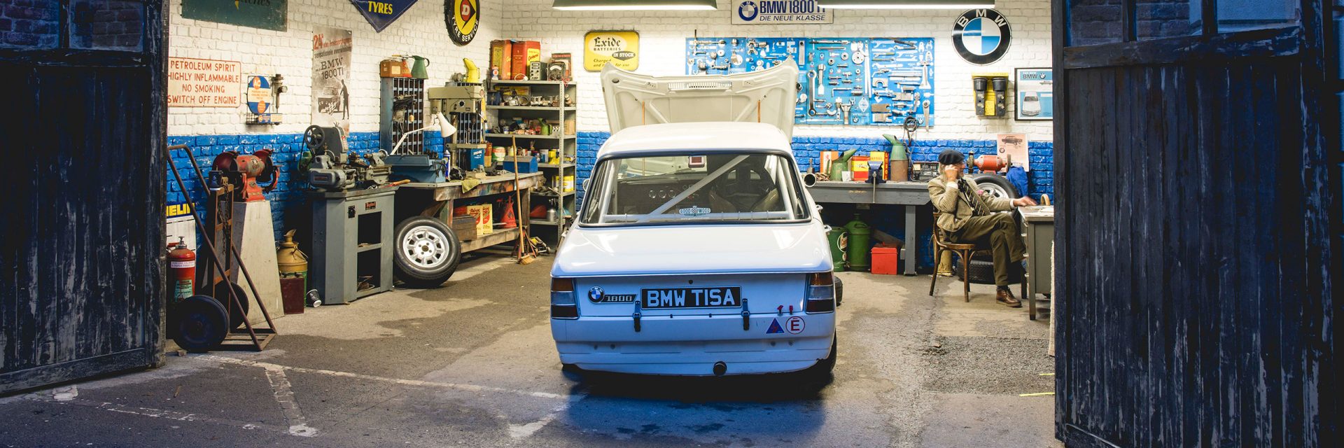 Ein BMW Oldtimer in einer Garage mit geöffneter Motorhaube.