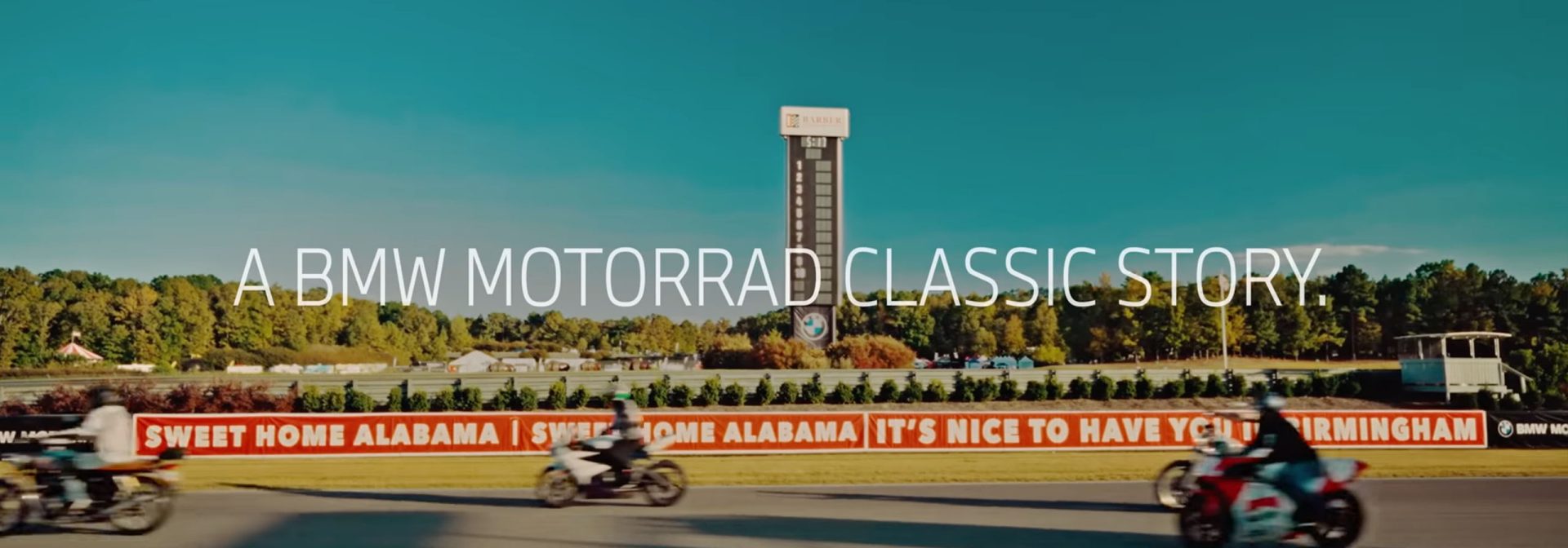 Motorräder rasen auf einer Rennstrecke, umgeben von dem Schriftzug "Eine BMW Motorrad Klassikgeschichte".