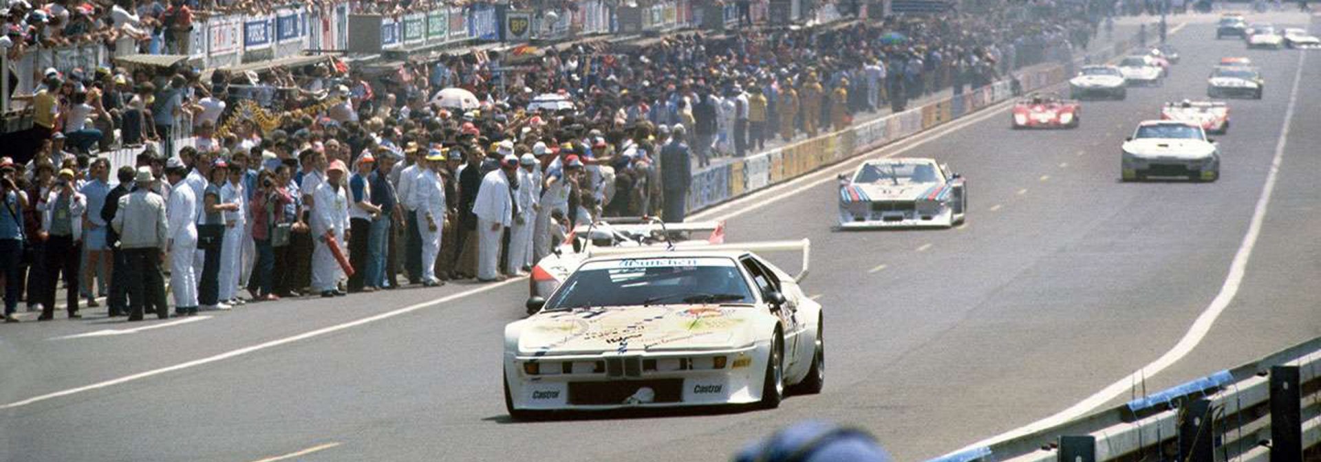 BMW M1 Rennwagen während des Rennens bei den 24 Stunden von Le Mans, umgeben von anderen Fahrzeugen auf der Strecke.