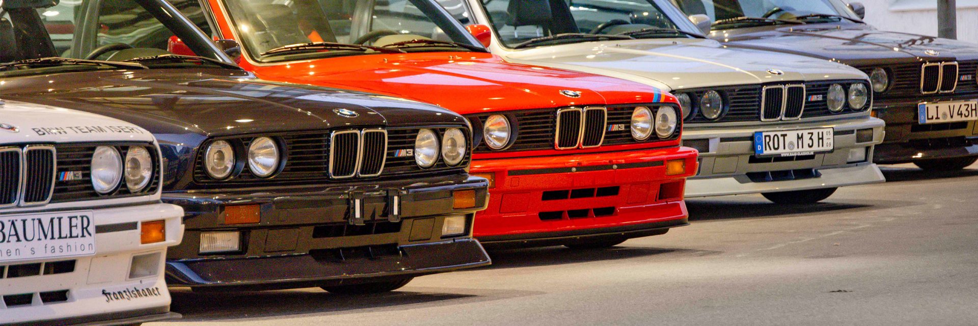Eine Reihe von BMW-Lkw, ordentlich hintereinander geparkt, zeigt die markante Fahrzeuglinie und das klassische Design.