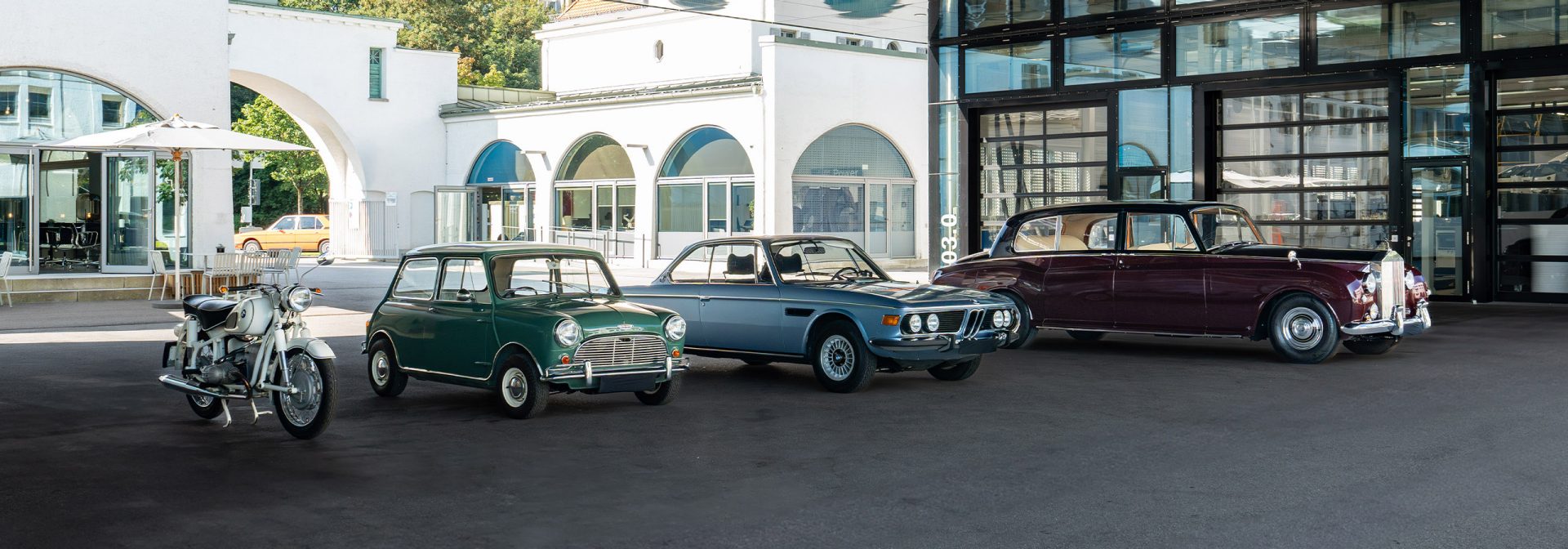BMW Classic Modelle stehen vor einem Gebäude und verkörpern den Charme und die Eleganz vergangener Zeiten.