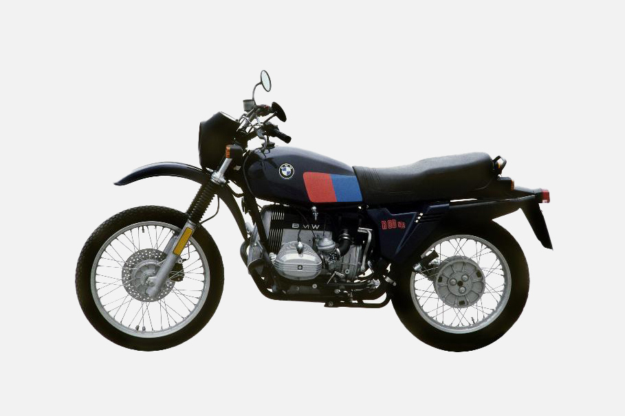 Seitenansicht der BMW R 80 G/S in schwarz, rot, blau mit schwarzer Sitzbank und Speichenrädern.