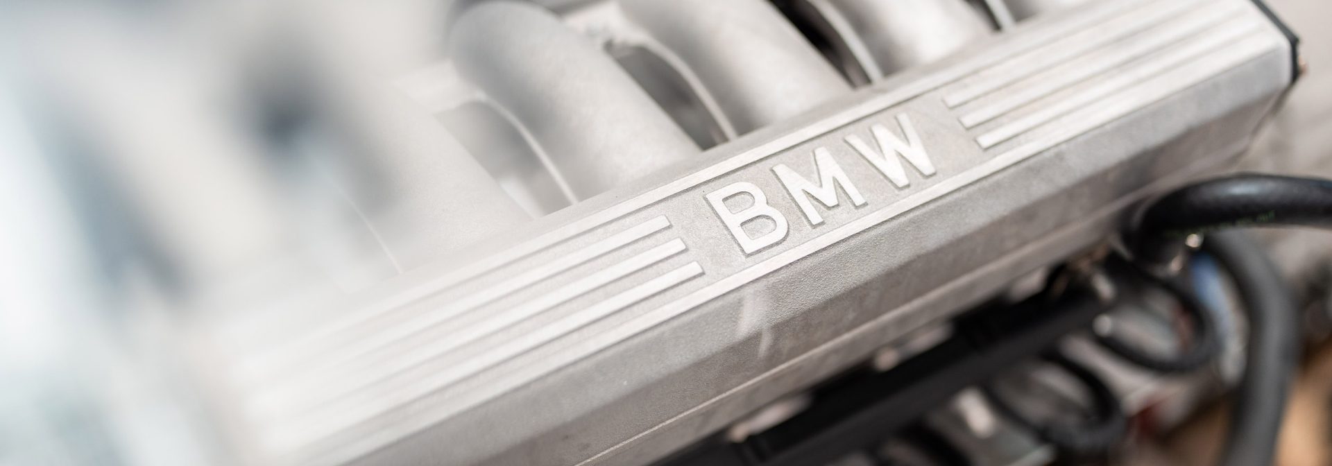 Motor eines BMW Fahrzeugs, der die technische Raffinesse und das klassische Design des Fahrzeugs zeigt.