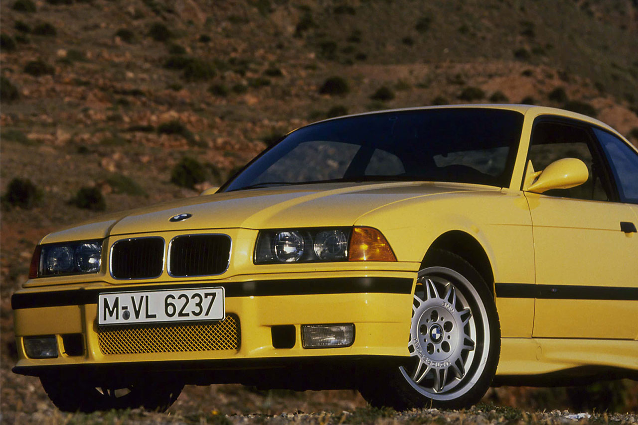 Front eines gelben 3er BMW der dritten Generation in der Natur