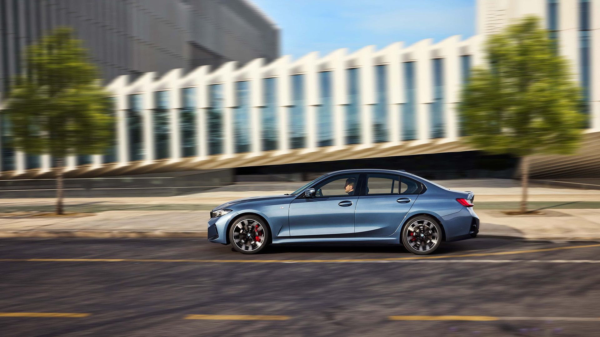 Seitenansicht eines blauen 3er BMW bei einer Fahrt durch die Stadt