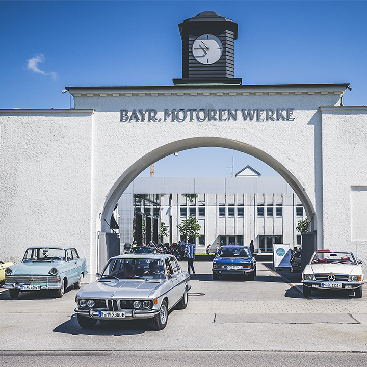 Zahlreiche Klassiker unterschiedlicher Marken vor dem Portal des ältesten BMW Werks in München, das inzwischen das BMW Museum beherbergt.