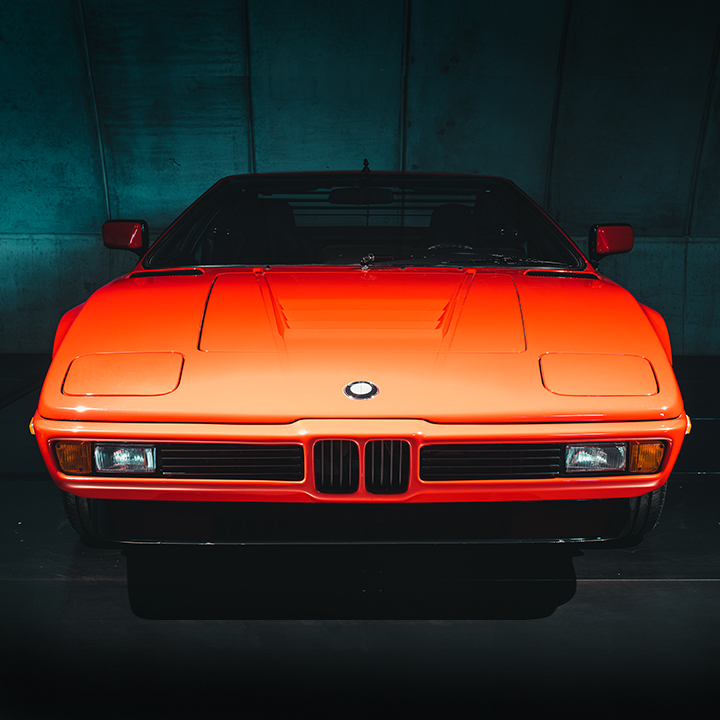 We see a BMW M1 (E26), a super sports car from BMW with a longitudinally mounted mid-engine and rear-wheel drive.