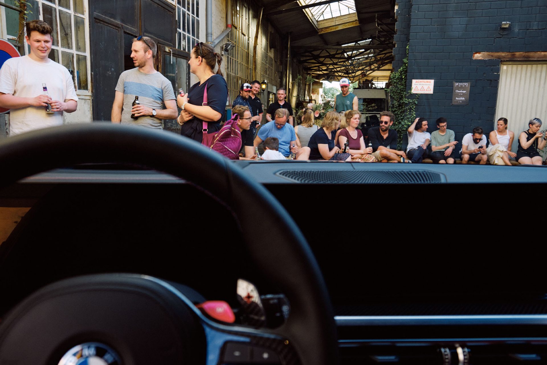 From inside a classic BMW, we look out at a large group of visitors.