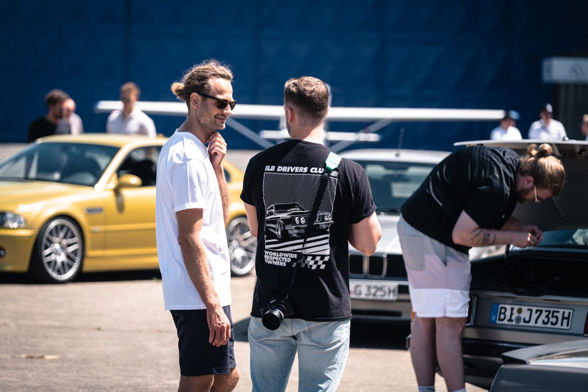 View of a group of visitors standing in front of and between various classic BMW.