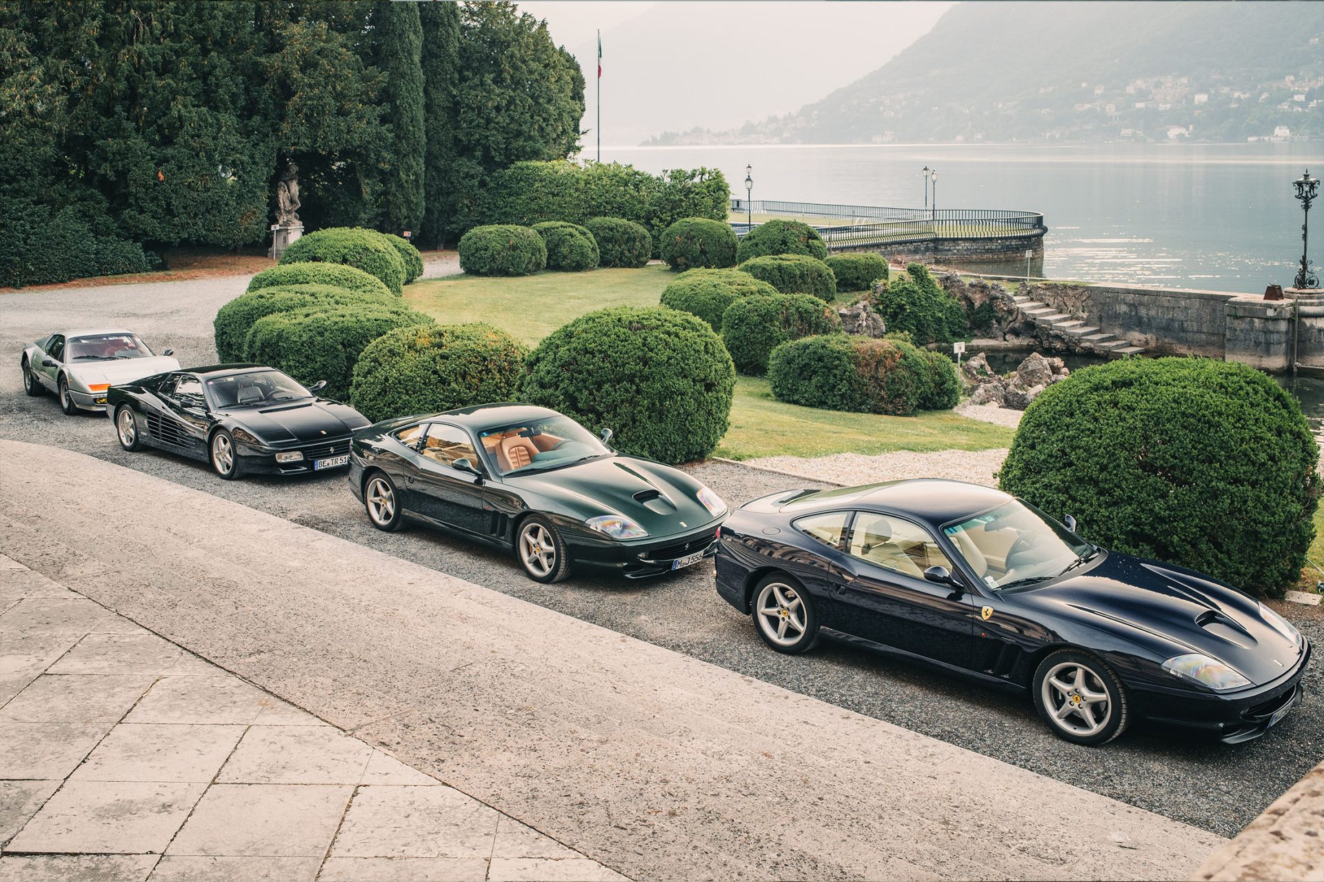 Several classic cars from different brands are located in the park of Villa d'Este overlooking Lake Como.