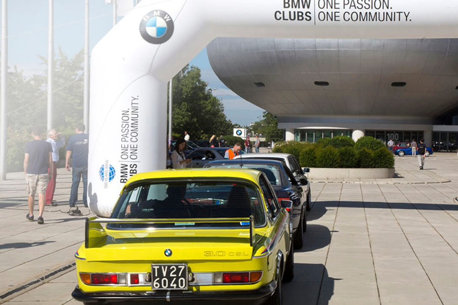 BMW vehicle driving enthusiastically through rough terrain, surrounded by nature.
