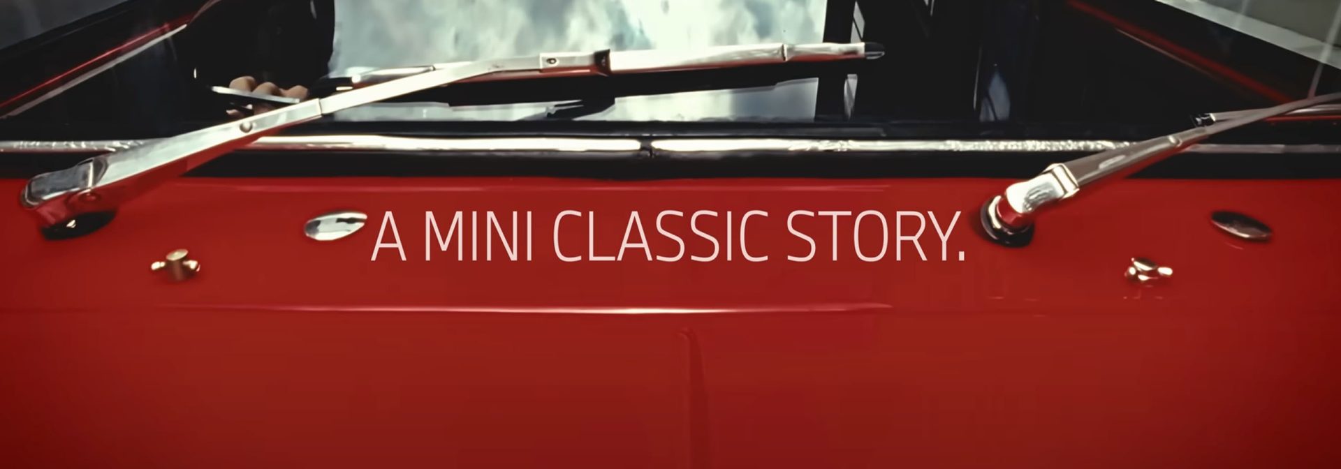 A red car with the inscription “A MINI classic story” on the side.