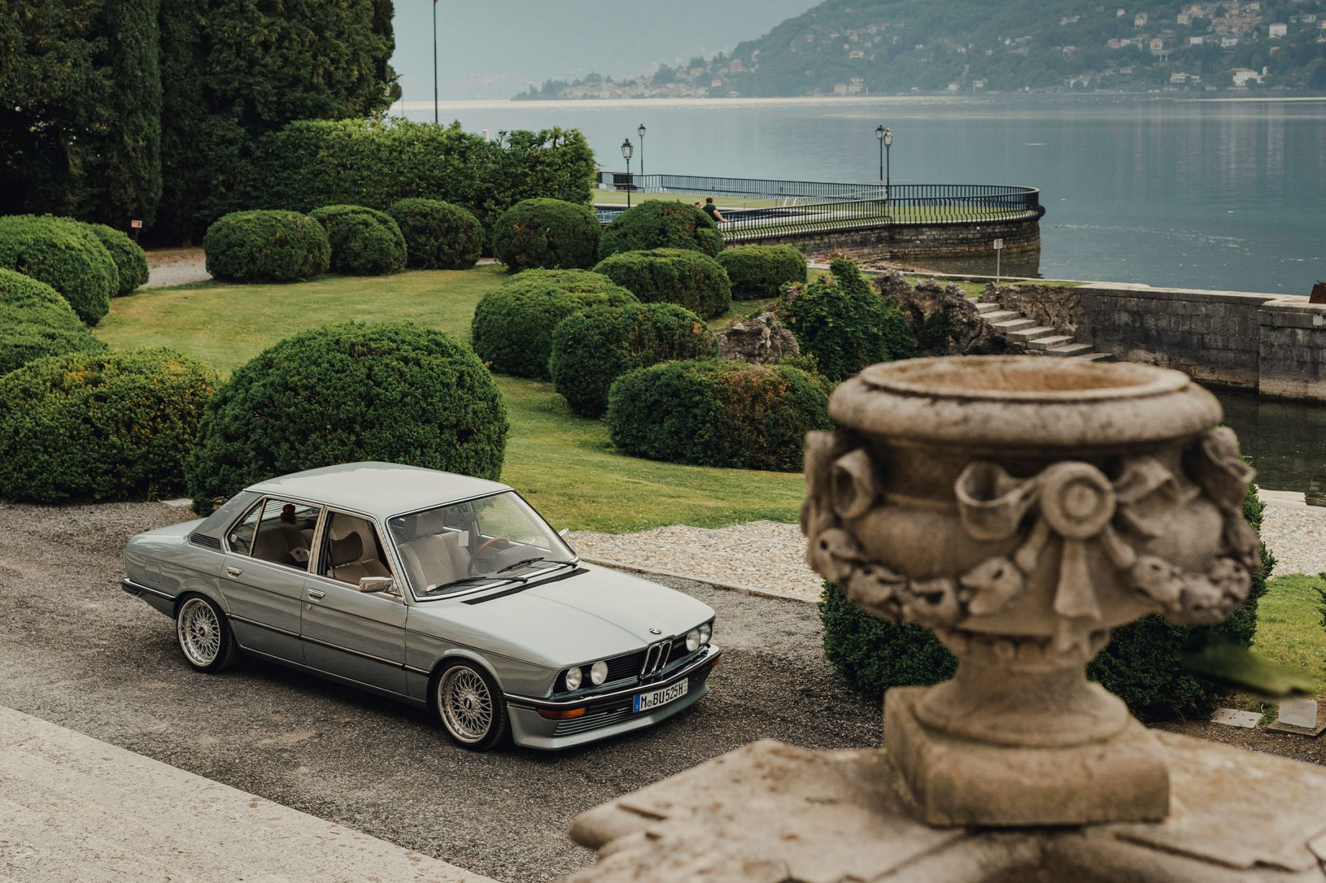 A silver BMW classic stands in the park of Villa d'Este overlooking Lake Como.
