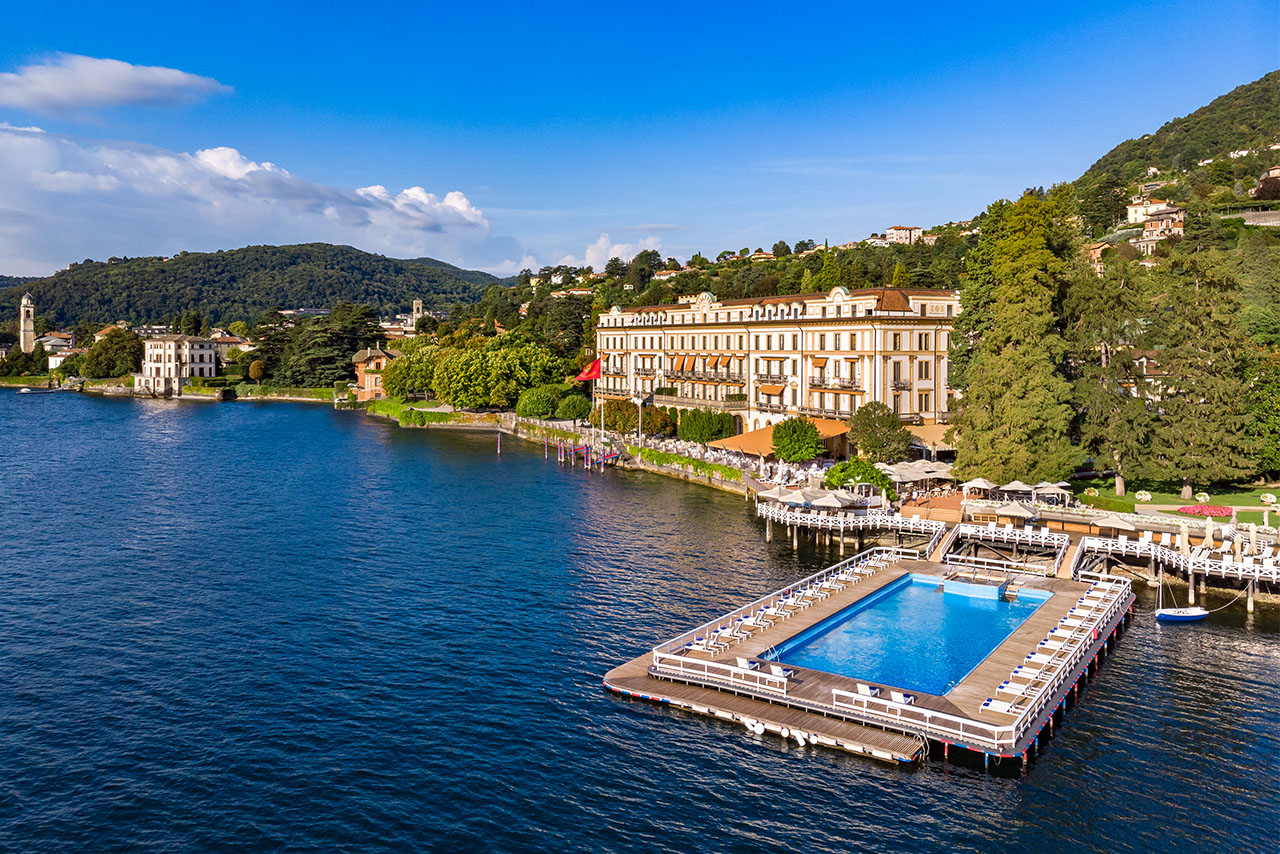 A picturesque lake with a hotel and a jetty, surrounded by natural beauty and a peaceful atmosphere.