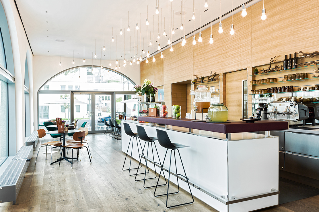 A view into the BMW Classic Cafe with bar stools and an Italian espresso machine for maximum coffee enjoyment.