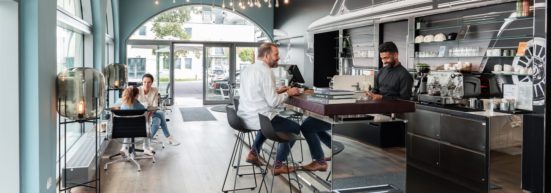 Inteior view of the BMW Group Classic Café with people enjoying their coffee.