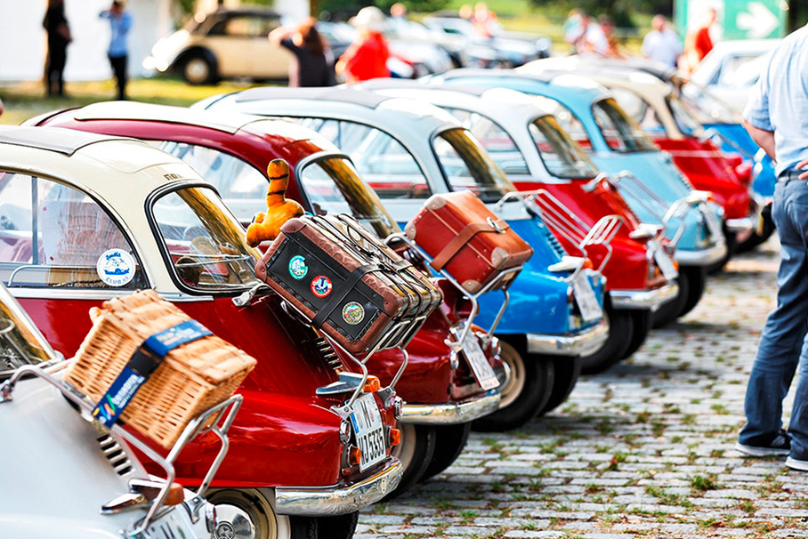 A colorful collection of BMW Isettas, presented in a row at an event, which also impress with their individual luggage solutions.