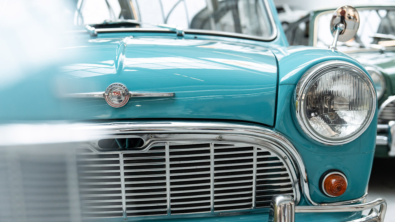 Close-up of the radiator grille with brand logo and the headlight of a Morris MINI Classic model.