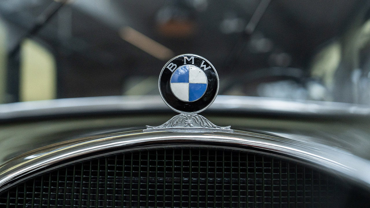The focus is on the white and blue BMW wing logo on the radiator of the BMW 3/20 Type AM 4, the first BMW in-house design.