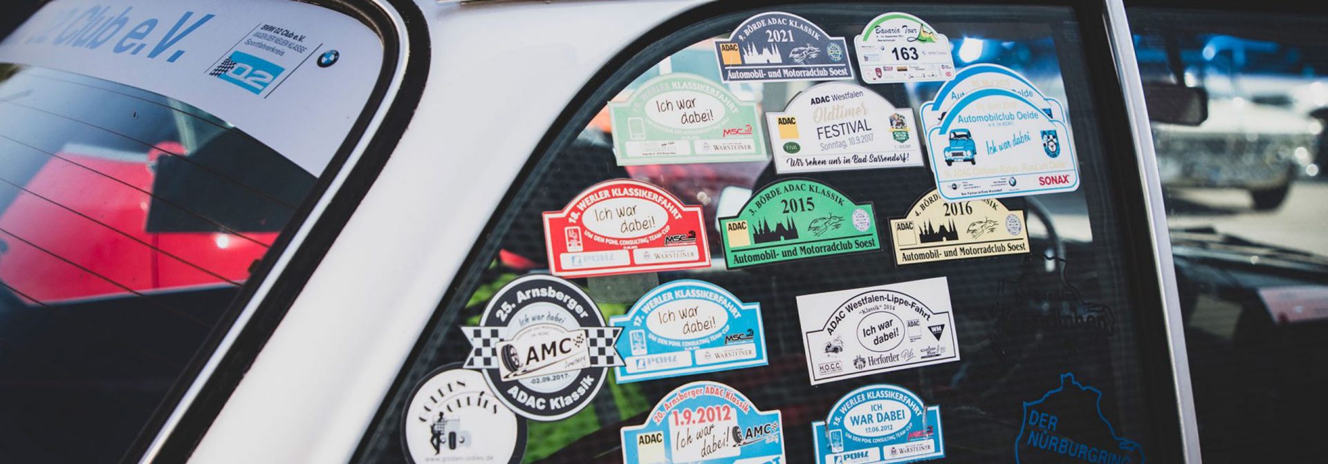 Vehicle with colorful stickers on the windows and an additional sticker on the rear window.