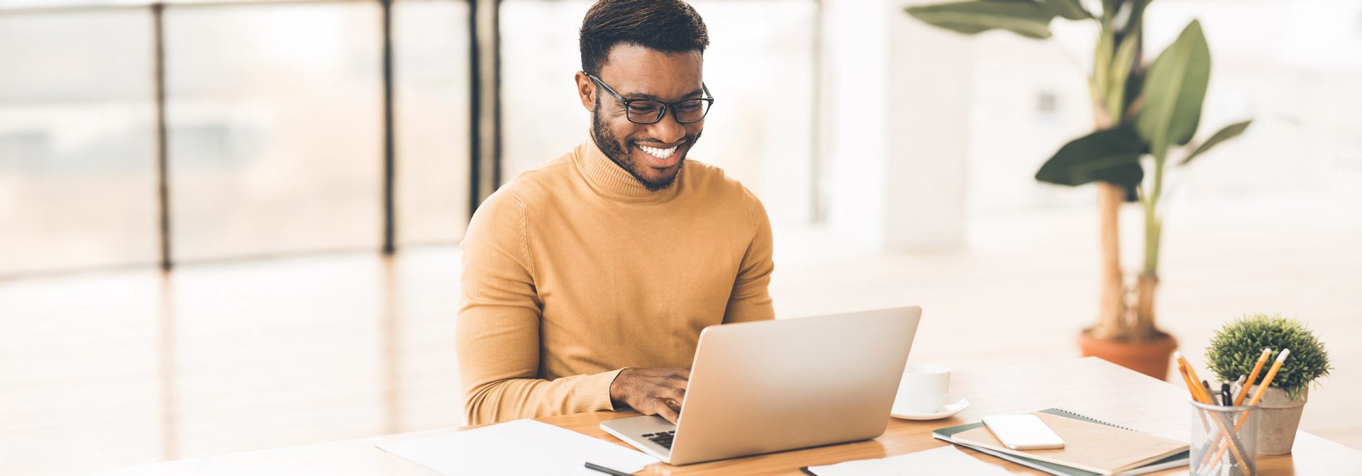 A man in an orange sweater at work.