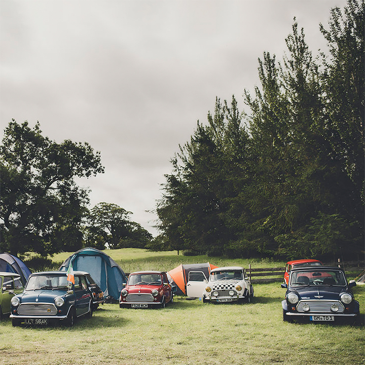 Vintage MINI cars parked on the grass at Laughton Showground, with tents behind the vehicles.