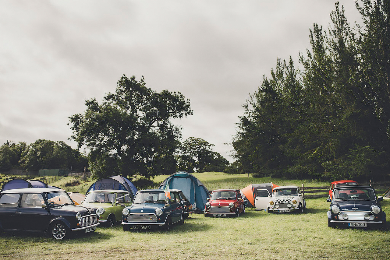 MINI Oldtimer, die auf dem Rasen des Laughton Showground geparkt sind, mit Zelten hinter den Fahrzeugen.