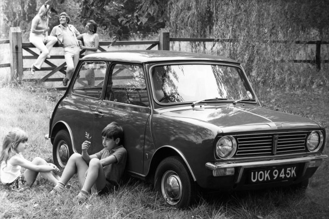 Junge und Mädchen neben MINI Oldtimer in Schwarz-Weiss