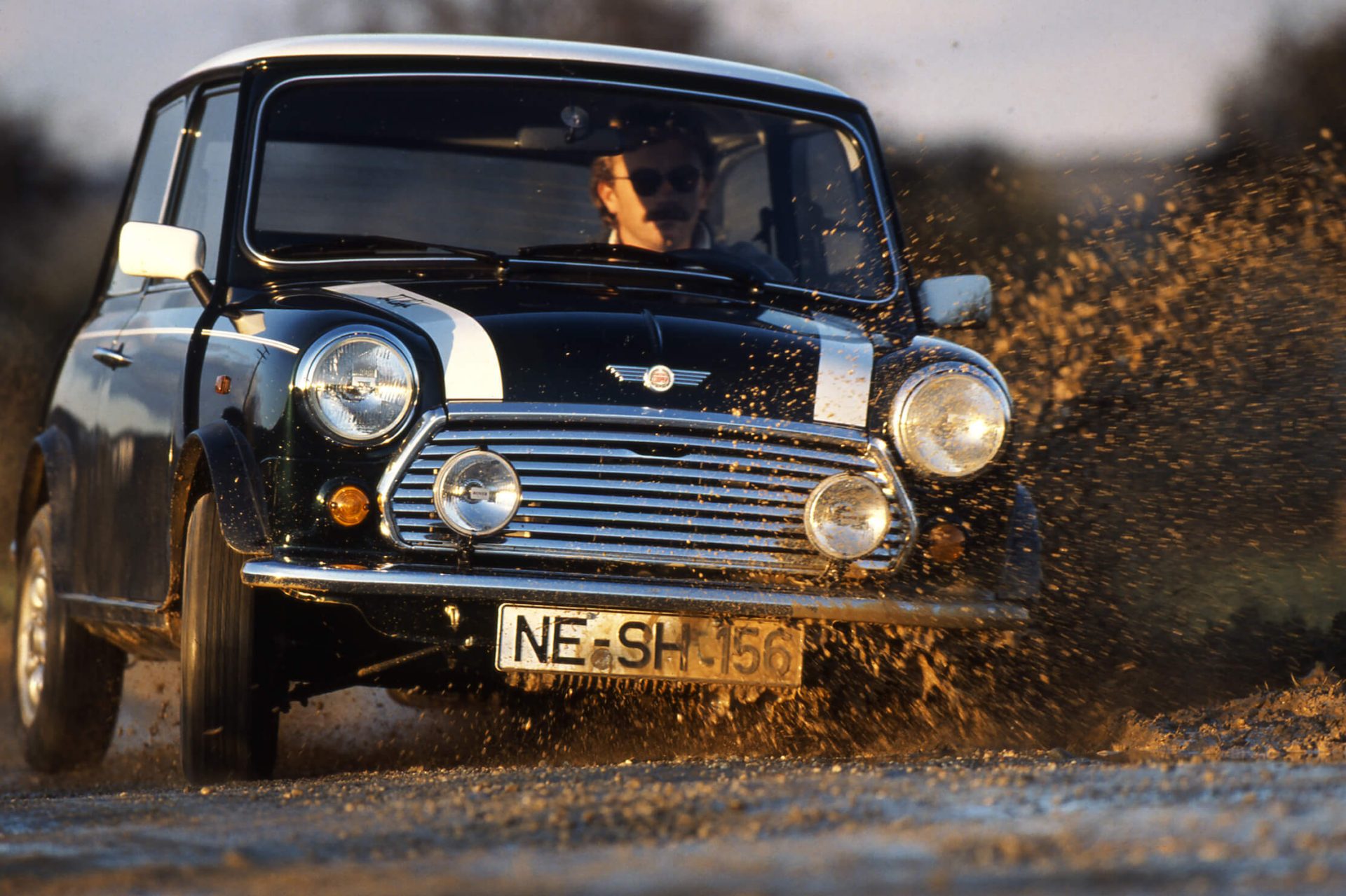 Junge und Mädchen neben MINI Oldtimer in Schwarz-Weiss