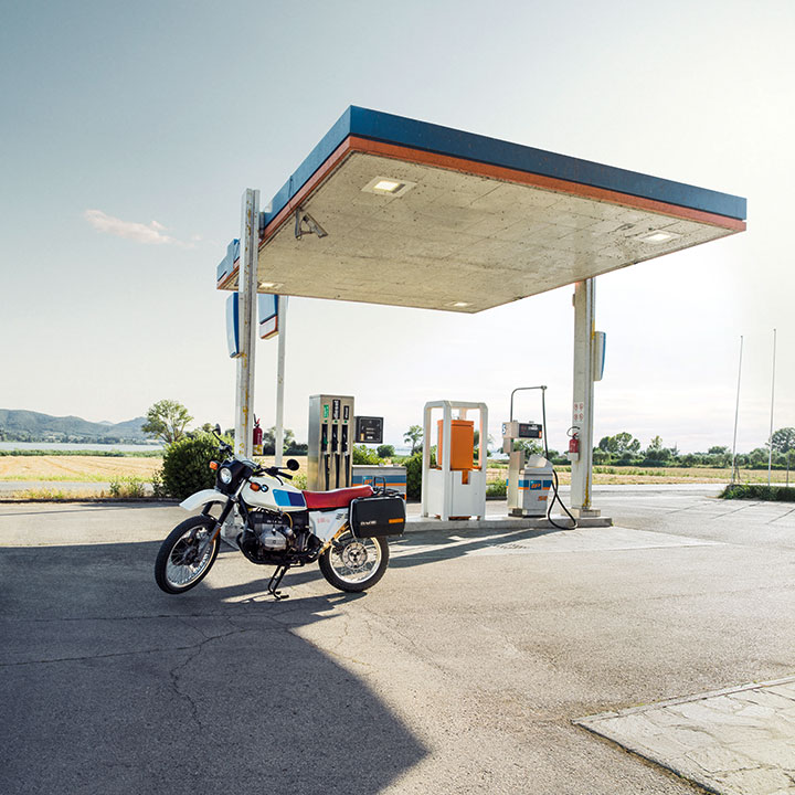 A motorbike is parked in front of a gas station