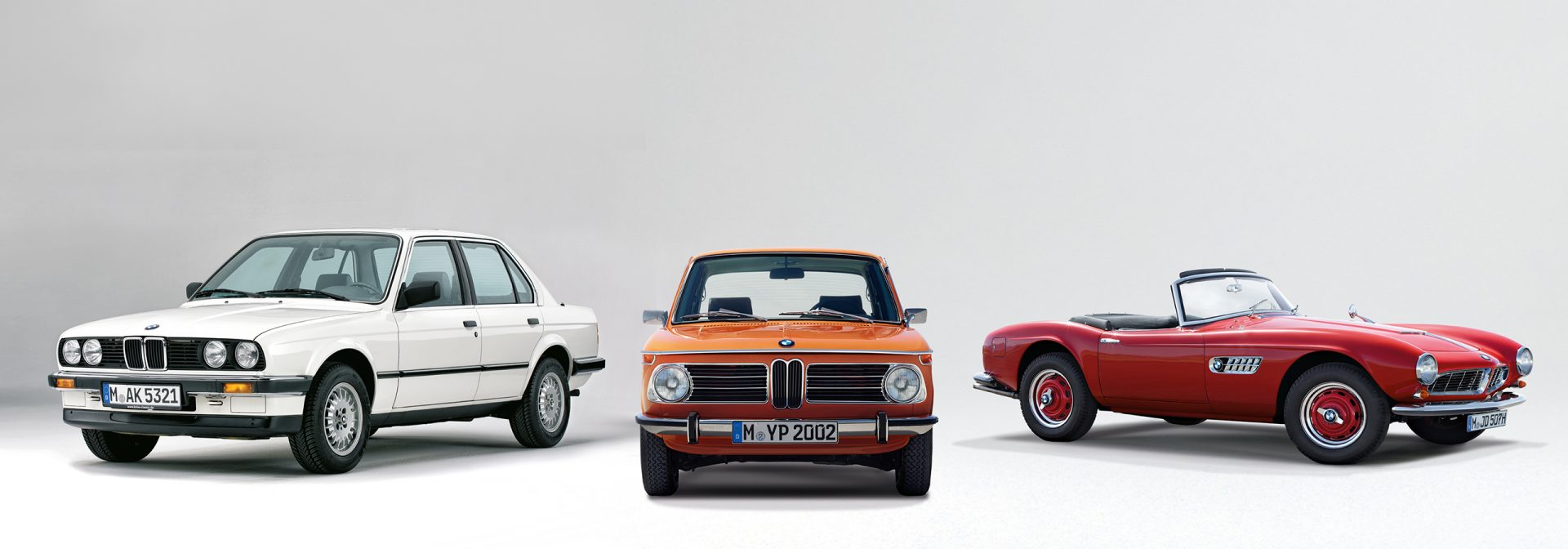 Three BMW models stand next to each other, surrounded by a white background.