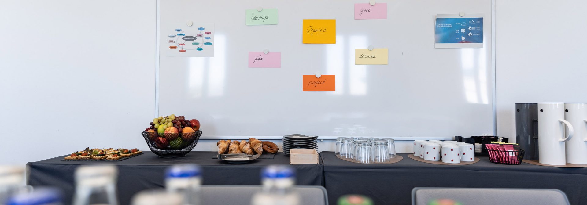 A set table in a BMW Classic workshop room, decorated with drinks and a selection of food.