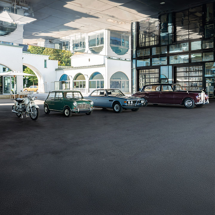 Various historical vehicle models of the BMW Group in front of the Classic building