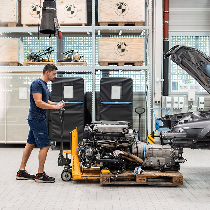A mechanic carries out maintenance work on a vehicle in a BMW Classic Garage.
