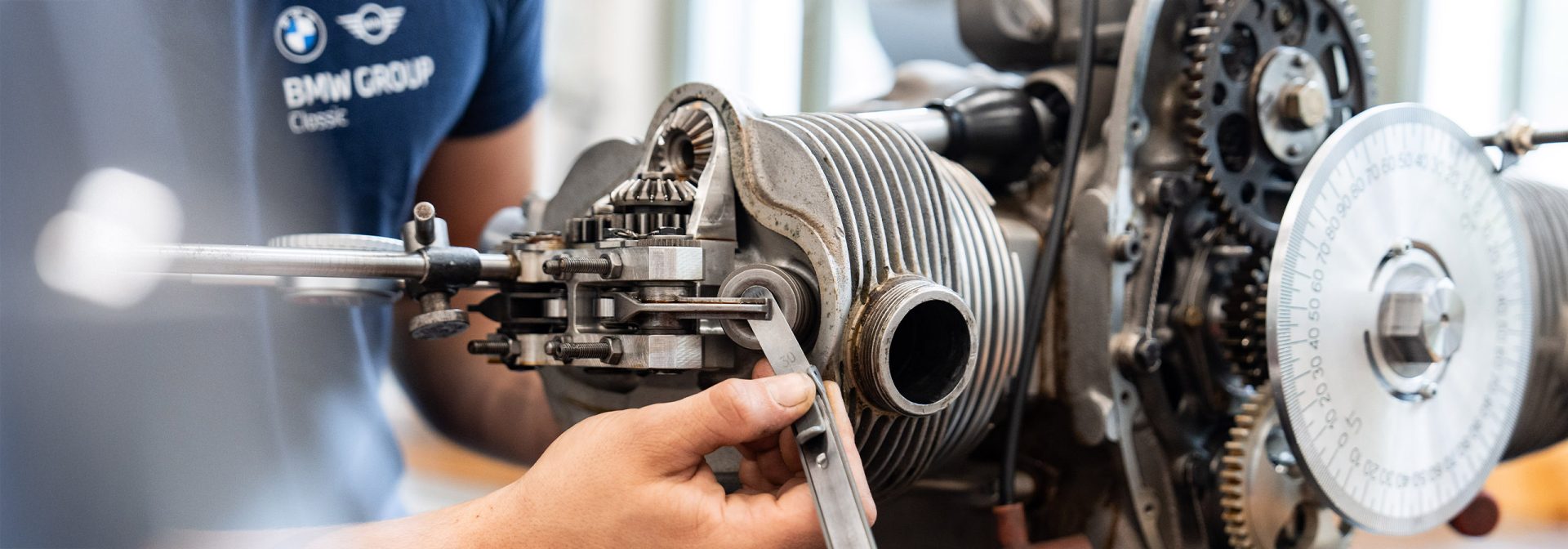 A specialist deals with the repair of a BMW engine in a professional environment.